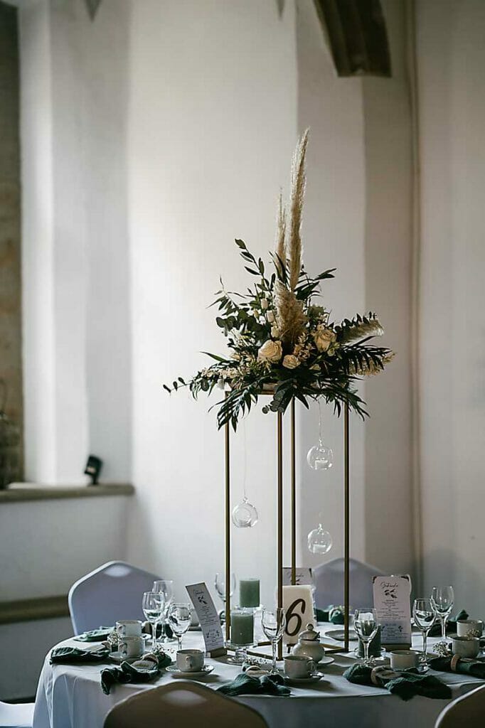 Ein Tisch mit einem hohen Tafelaufsatz und Kerzen, perfekt für Ihre Hochzeit und inspiriert von expert Hochzeitsplanung. Unser Zelt für Ihr Event in Leipzig und Umgebung.